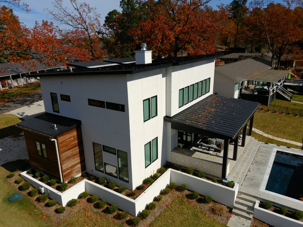 Matte black metal roof highlights wood accents of modern home.